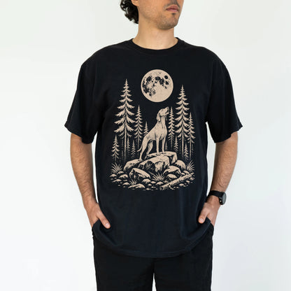 Model wearing a Black Comfort Colors® T-shirt with a Vizsla howling beneath the moon and pine trees