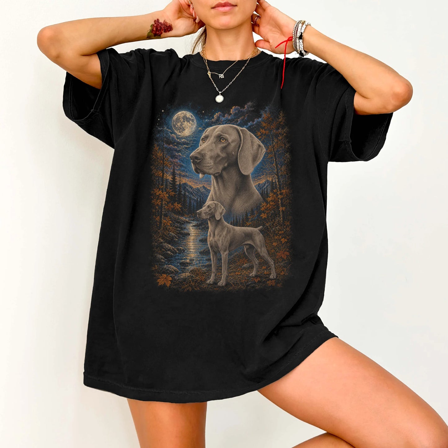 Model wearing a Black Comfort Colors® t-shirt featuring Weimaraner in a moonlit fall forest