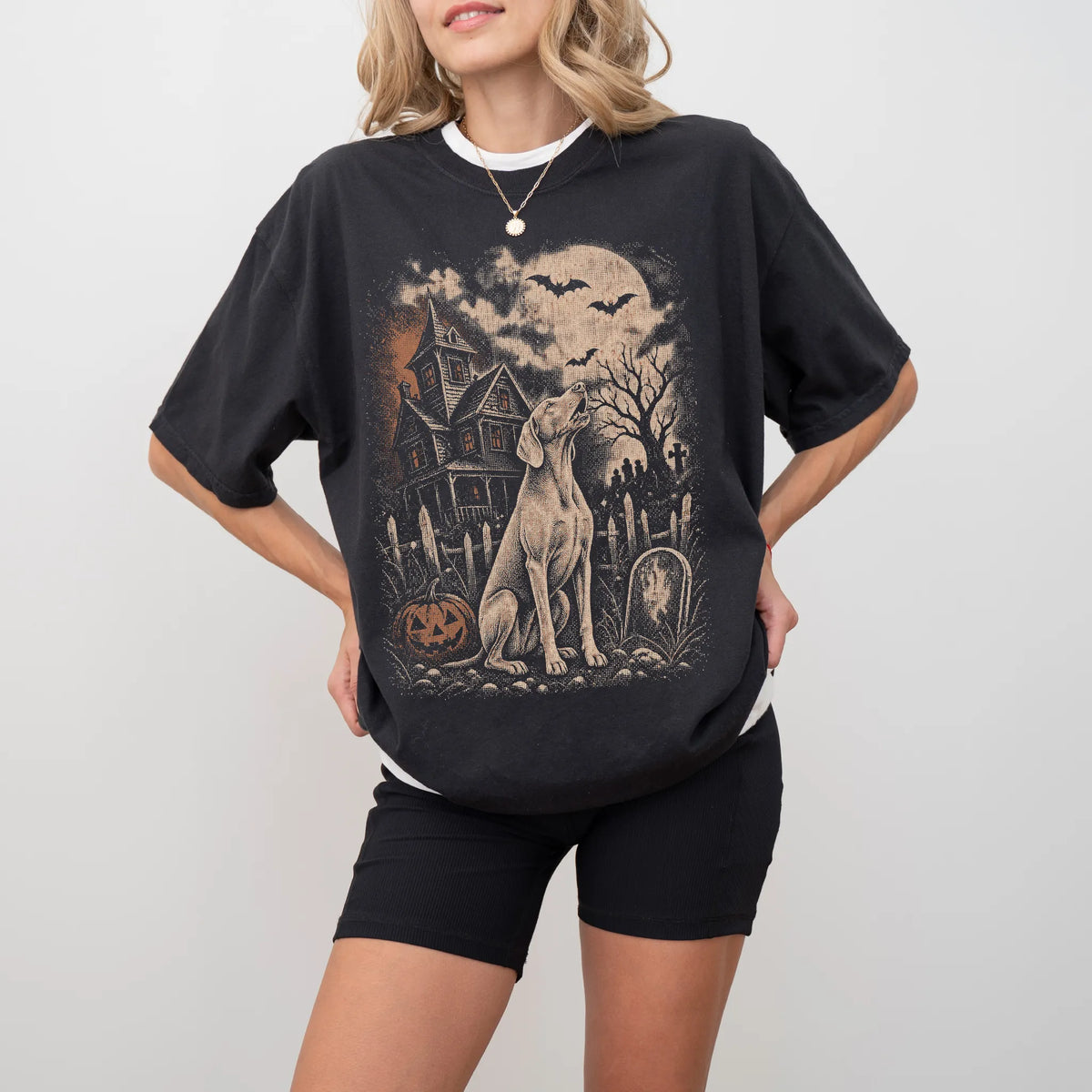 Model wearing a Black Comfort Colors® T-shirt showing Weimaraner in a vintage haunted-house scene
