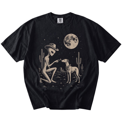 Cowboy alien fist-bumping a Whippet beneath the moon on a Black Comfort Colors® T-shirt