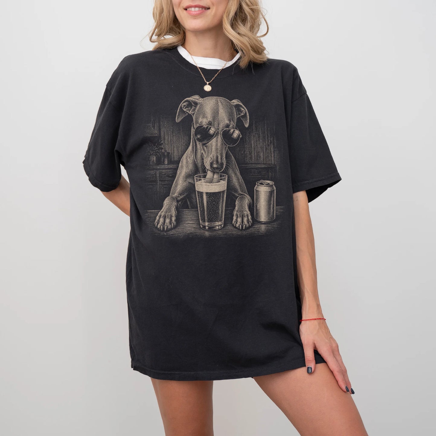 Model wearing a Black Comfort Colors® t-shirt with Whippet sneaking a drink from a pint