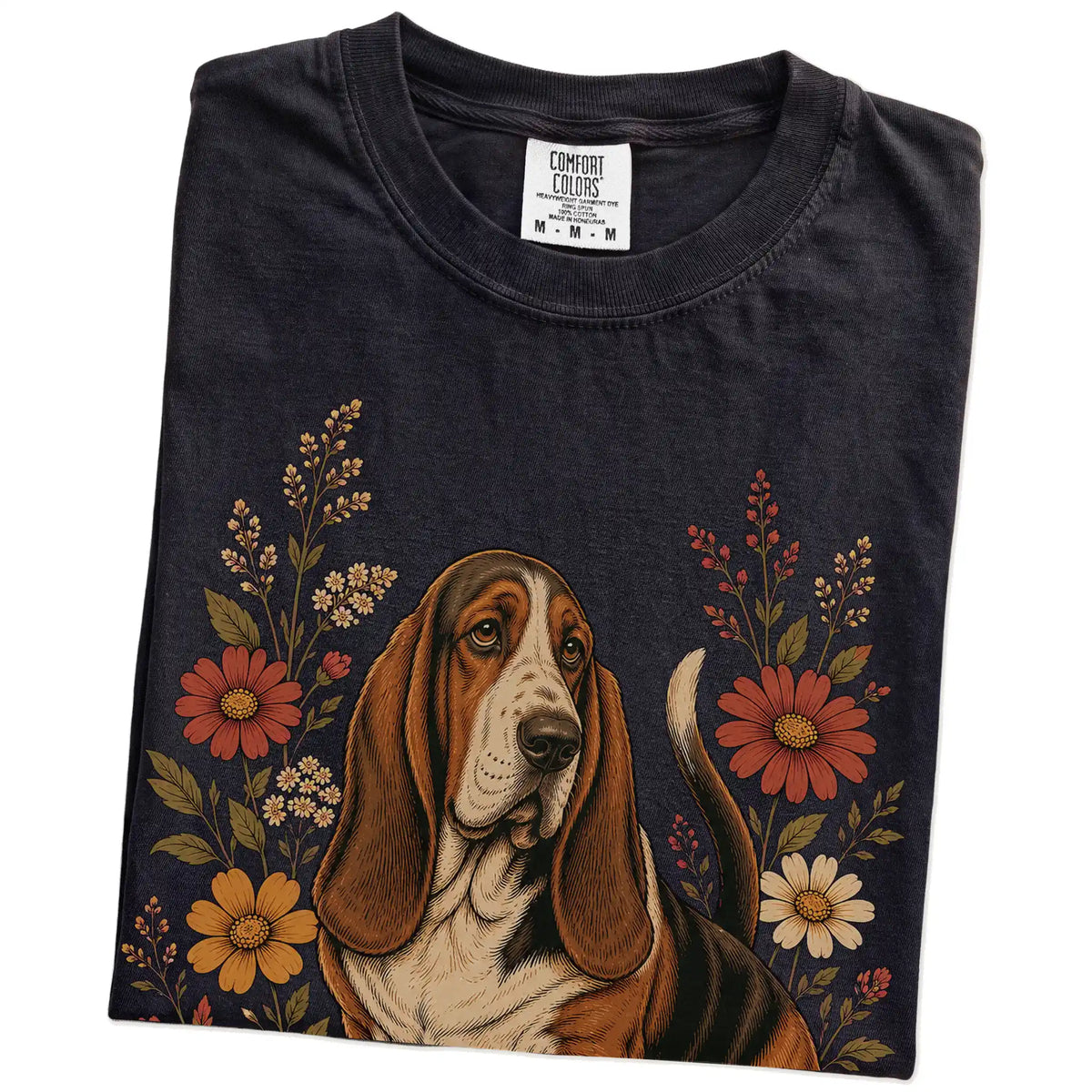 Folded Black Comfort Colors® T-shirt showing Basset Hound portrait surrounded by wildflowers beneath the moon