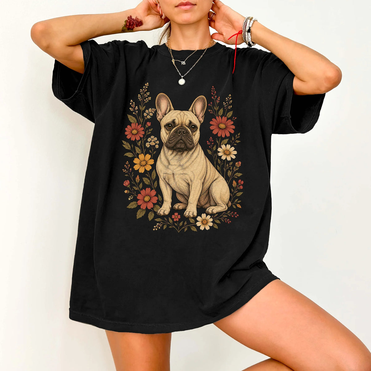 Model wearing a Black Comfort Colors® T-shirt showing French Bulldog portrait surrounded by wildflowers beneath the moon