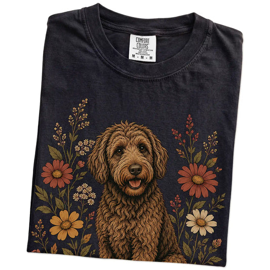 Folded Black Comfort Colors® T-shirt showing Labradoodle portrait surrounded by wildflowers beneath the moon