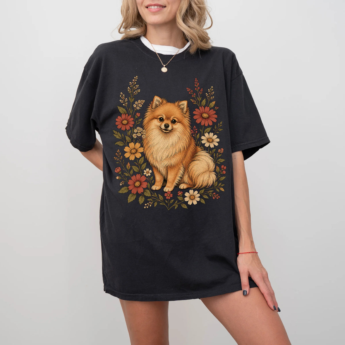Model wearing a Black Comfort Colors® T-shirt showing Pomeranian portrait surrounded by wildflowers beneath the moon