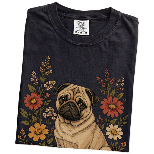 Folded Black Comfort Colors® T-shirt showing Pug portrait surrounded by wildflowers beneath the moon