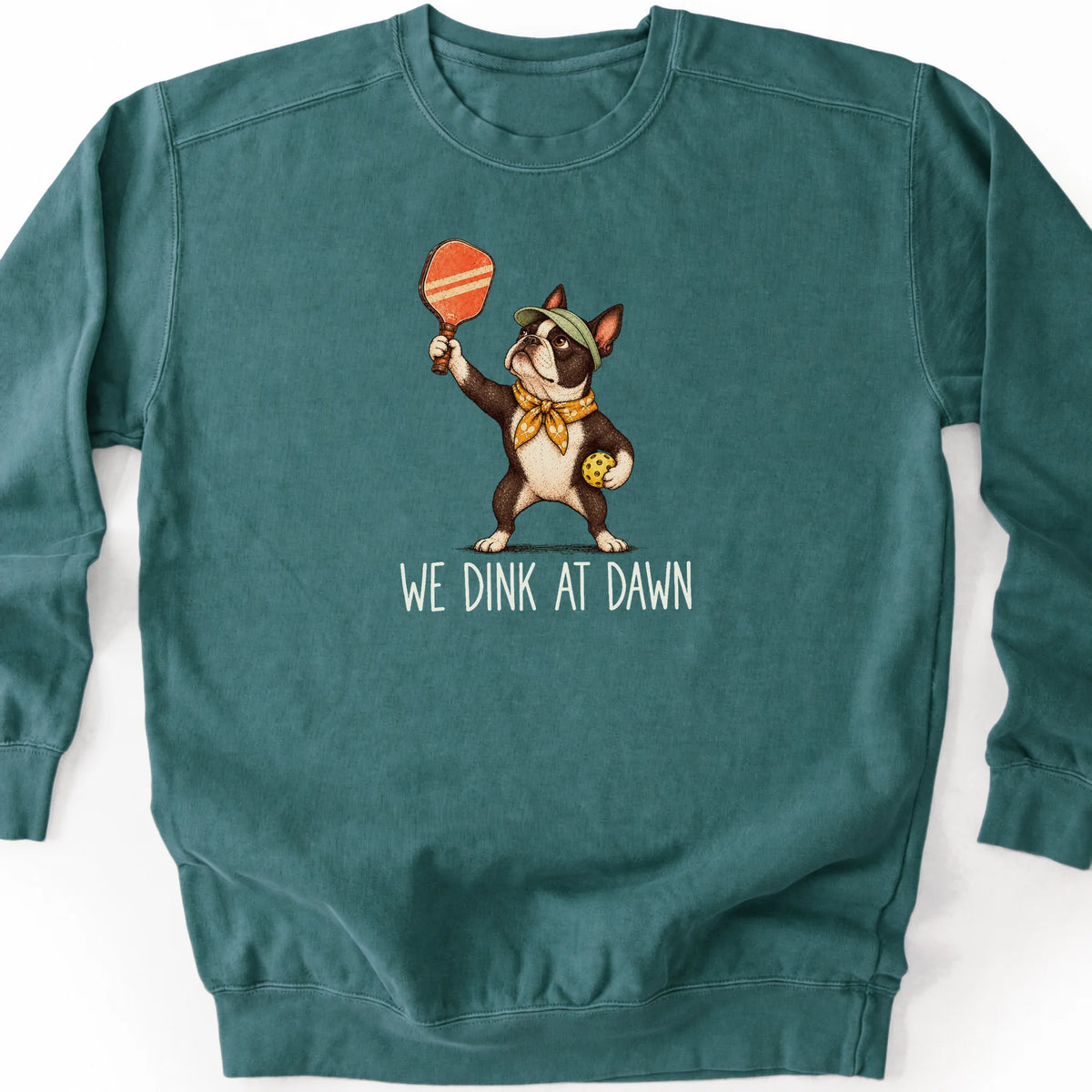 Boston Terrier with a pickleball paddle and ball on a Blue Spruce Comfort Colors® sweatshirt with We Dink at Dawn text