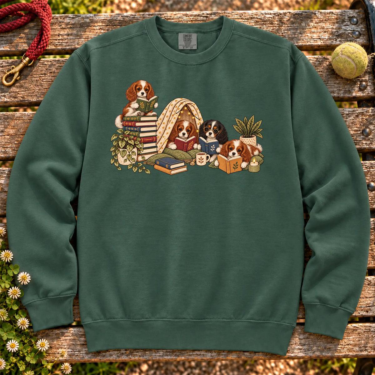 Cavalier King Charles Spaniel puppies reading books in a cozy blanket fort on a Blue Spruce sweatshirt