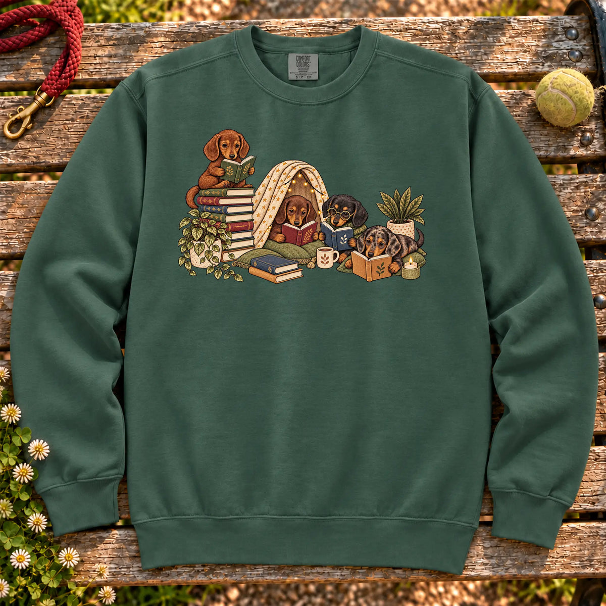 Dachshund puppies reading books in a cozy blanket fort on a Blue Spruce sweatshirt