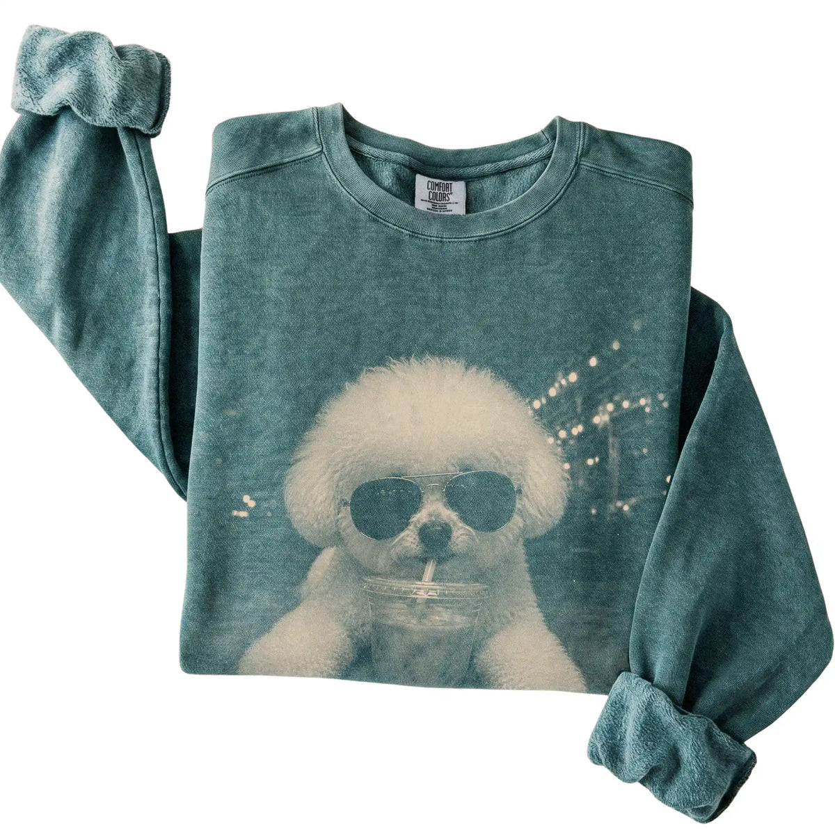 Bichon Frise wearing aviator sunglasses and drinking iced coffee on a Blue Spruce Comfort Colors 1566 Sweatshirt, folded view