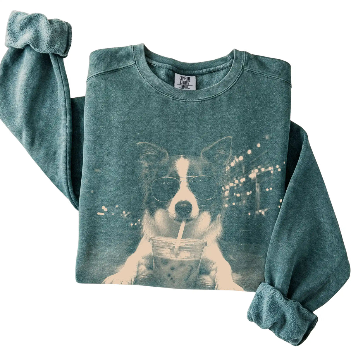 Border Collie wearing aviator sunglasses and drinking iced coffee on a Blue Spruce Comfort Colors 1566 Sweatshirt, folded view