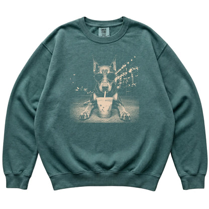 Doberman wearing aviator sunglasses and drinking iced coffee on a Blue Spruce Comfort Colors 1566 Sweatshirt, flat lay view