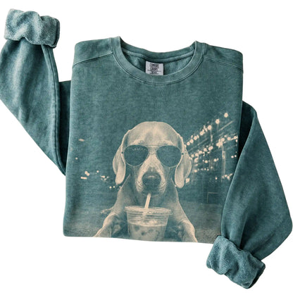 Weimaraner wearing aviator sunglasses and drinking iced coffee on a Blue Spruce Comfort Colors 1566 Sweatshirt, folded view