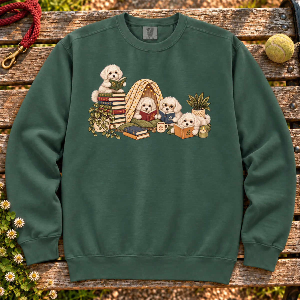 Maltese puppies reading books in a cozy blanket fort on a Blue Spruce sweatshirt