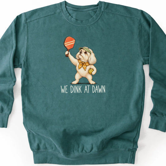 Maltese with a pickleball paddle and ball on a Blue Spruce Comfort Colors® sweatshirt with We Dink at Dawn text