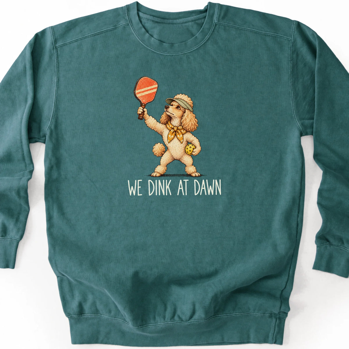 Poodle with a pickleball paddle and ball on a Blue Spruce Comfort Colors® sweatshirt with We Dink at Dawn text