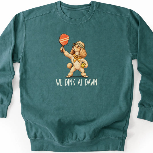 Poodle with a pickleball paddle and ball on a Blue Spruce Comfort Colors® sweatshirt with We Dink at Dawn text