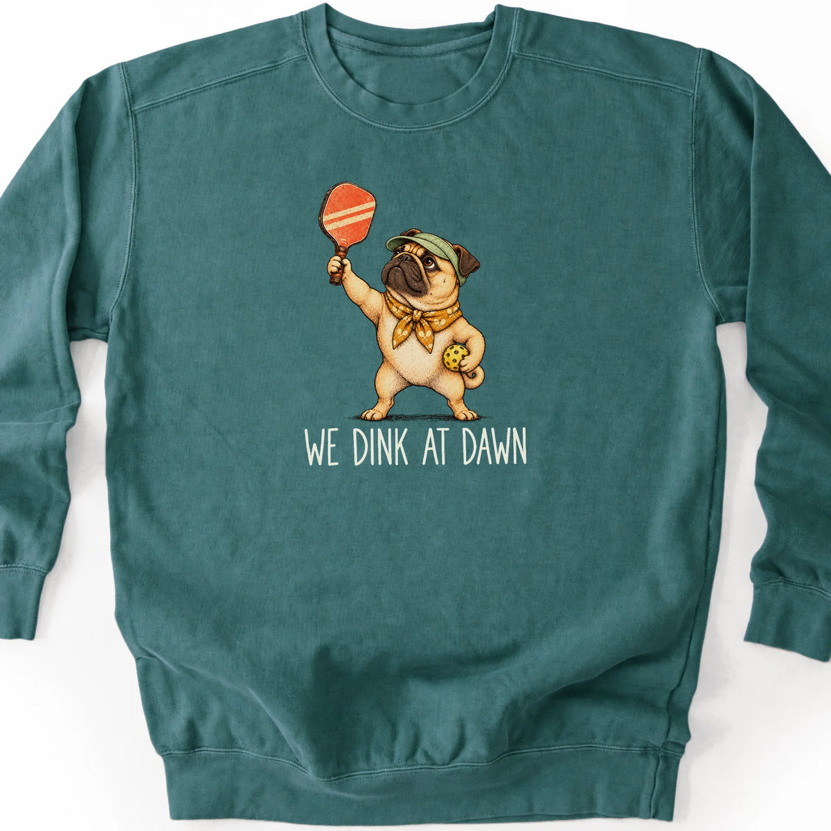 Pug with a pickleball paddle and ball on a Blue Spruce Comfort Colors® sweatshirt with We Dink at Dawn text