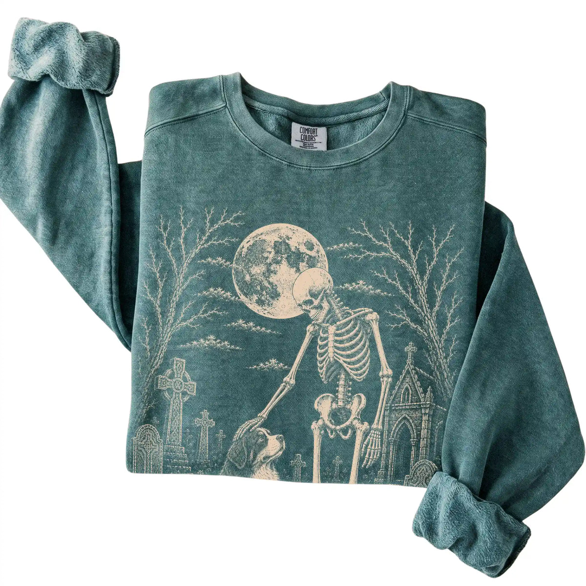Folded Blue Spruce sweatshirt with a skeleton petting a Bernese Mountain Dog in a graveyard