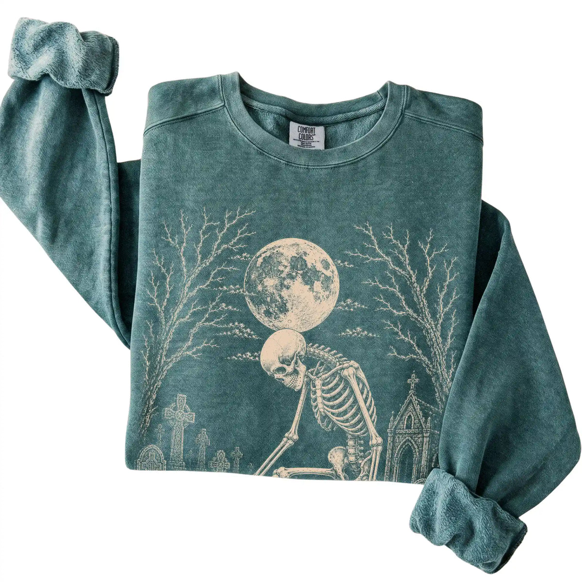 Folded Blue Spruce sweatshirt with a skeleton petting a Corgi in a graveyard