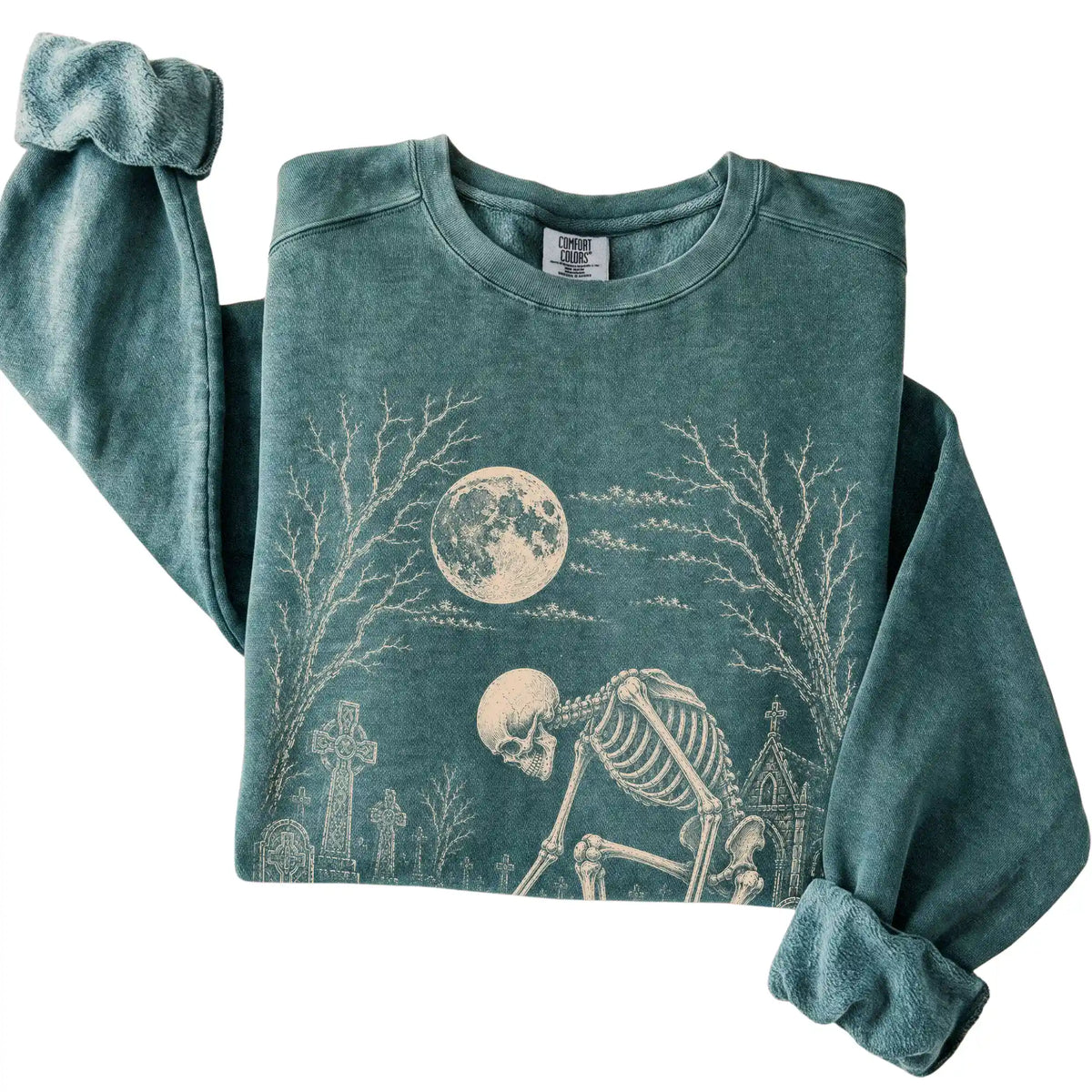 Folded Blue Spruce sweatshirt with a skeleton petting a Dachshund in a graveyard