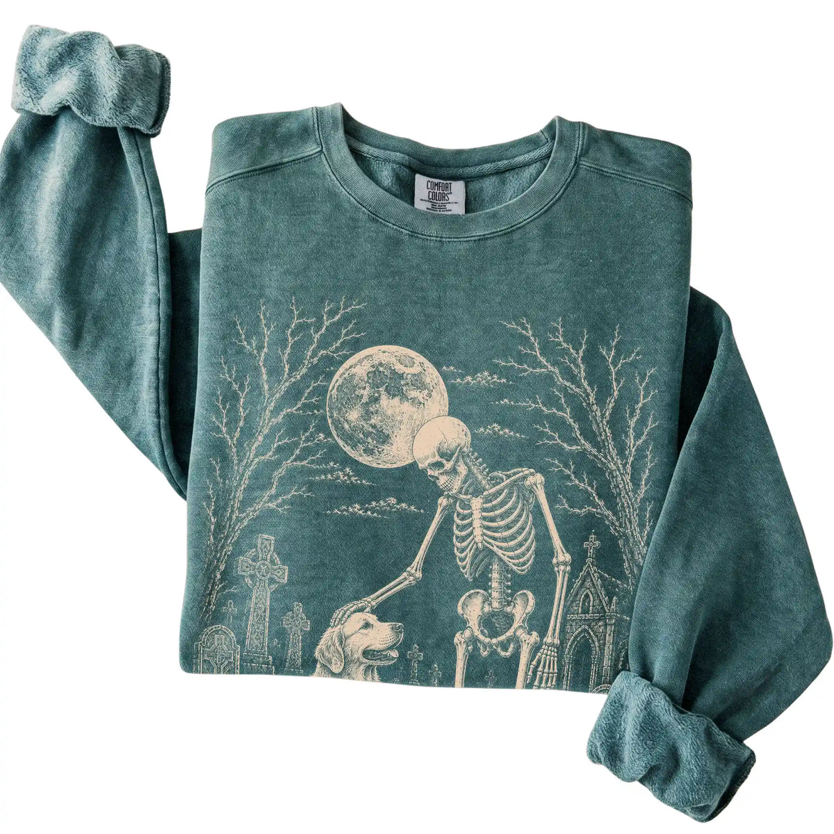 Folded Blue Spruce sweatshirt with a skeleton petting a Golden Retriever in a graveyard
