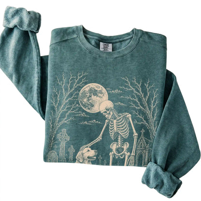 Folded Blue Spruce sweatshirt with a skeleton petting a Golden Retriever in a graveyard