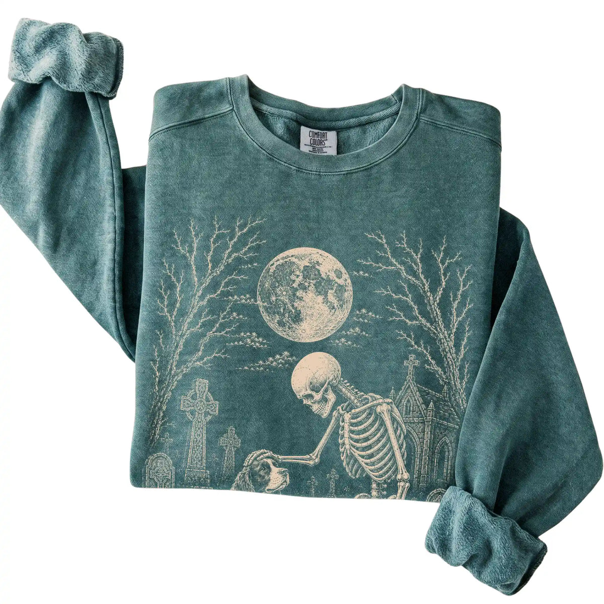 Folded Blue Spruce sweatshirt with a skeleton petting a Springer Spaniel in a graveyard