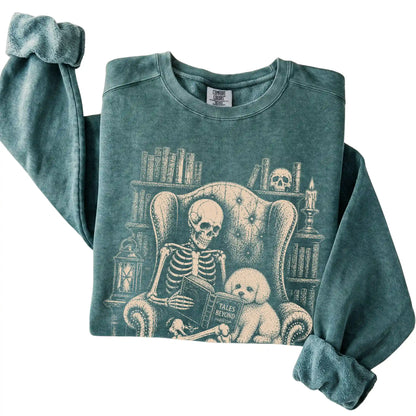 Folded Blue Spruce sweatshirt with a skeleton reading Tales Beyond to a Bichon Frise