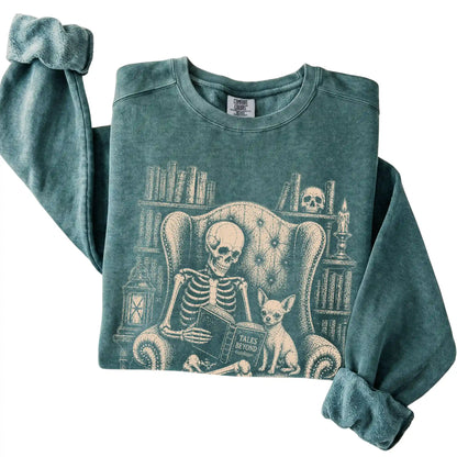 Folded Blue Spruce sweatshirt with a skeleton reading Tales Beyond to a Chihuahua