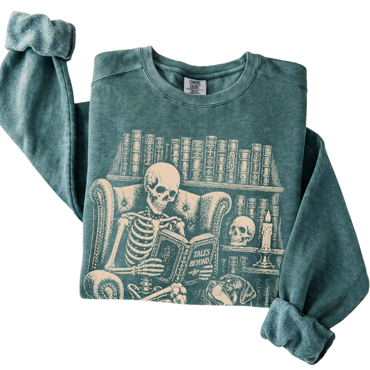 Folded Blue Spruce sweatshirt with a skeleton reading Tales Beyond to a Rottweiler
