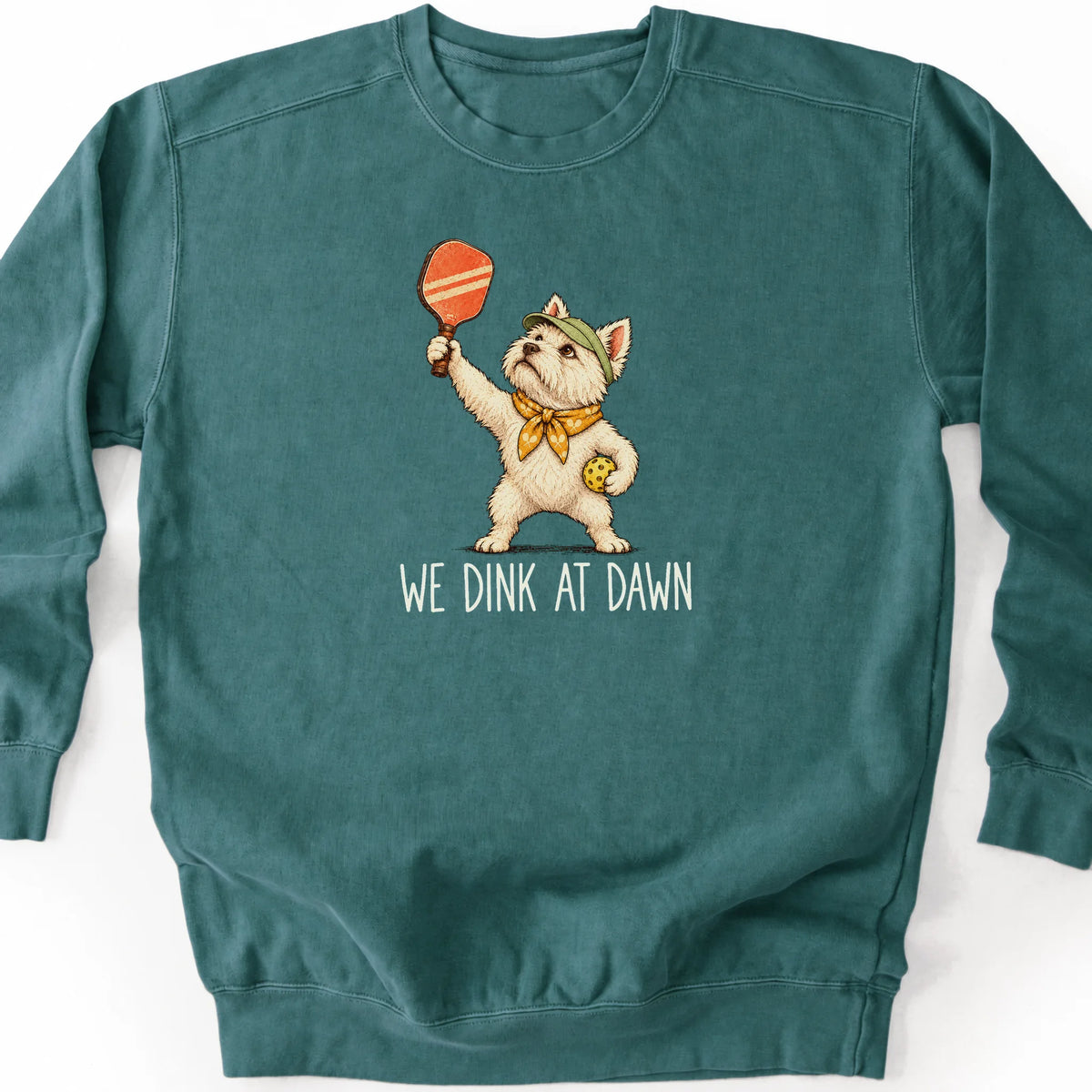 Westie with a pickleball paddle and ball on a Blue Spruce Comfort Colors® sweatshirt with We Dink at Dawn text