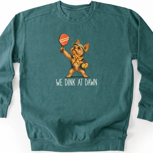 Yorkie with a pickleball paddle and ball on a Blue Spruce Comfort Colors® sweatshirt with We Dink at Dawn text