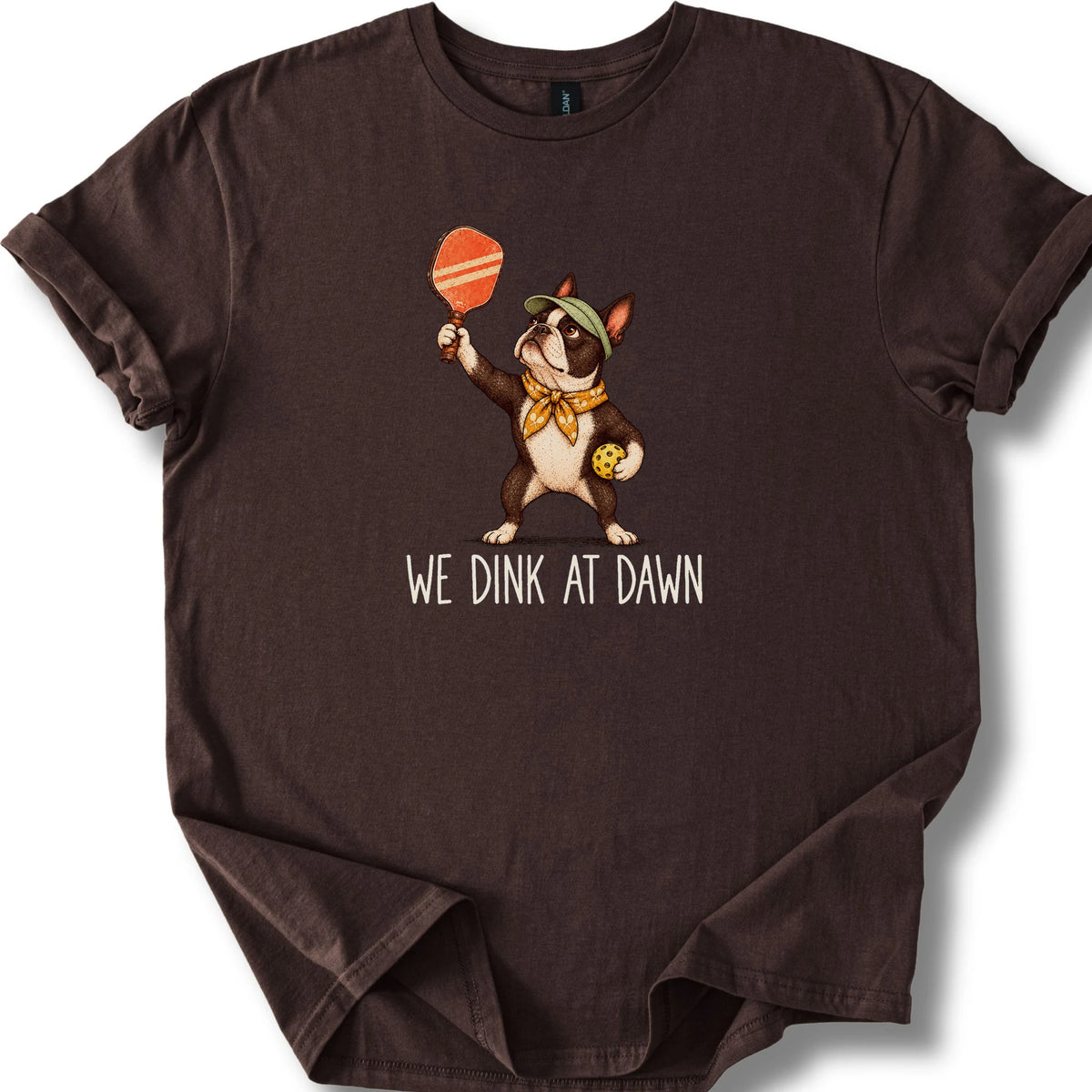 Boston Terrier with a pickleball paddle and ball on a Dark Chocolate Gildan® T-shirt with We Dink at Dawn text