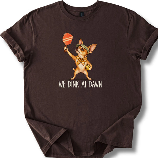 Chihuahua with a pickleball paddle and ball on a Dark Chocolate Gildan® T-shirt with We Dink at Dawn text