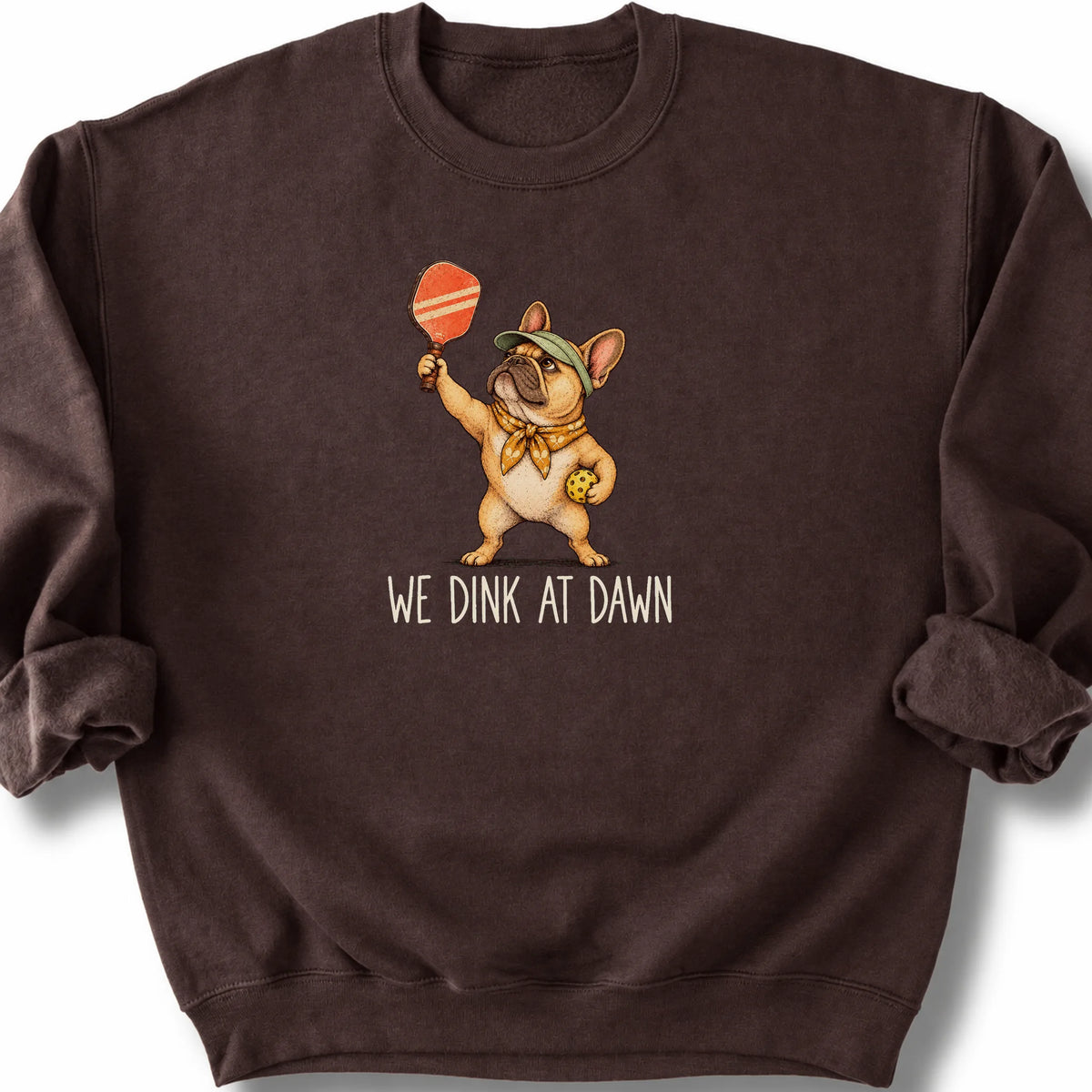 French Bulldog with a pickleball paddle and ball on a Dark Chocolate Gildan® sweatshirt with We Dink at Dawn text