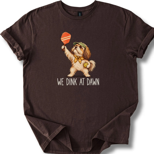 Havanese with a pickleball paddle and ball on a Dark Chocolate Gildan® T-shirt with We Dink at Dawn text