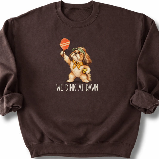 Shih Tzu with a pickleball paddle and ball on a Dark Chocolate Gildan® sweatshirt with We Dink at Dawn text