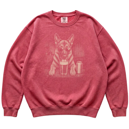 Crimson German Shepherd drinking from a pint at a bar, laid flat
