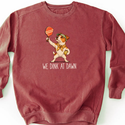 Jack Russell with a pickleball paddle and ball on a Crimson Comfort Colors® sweatshirt with We Dink at Dawn text
