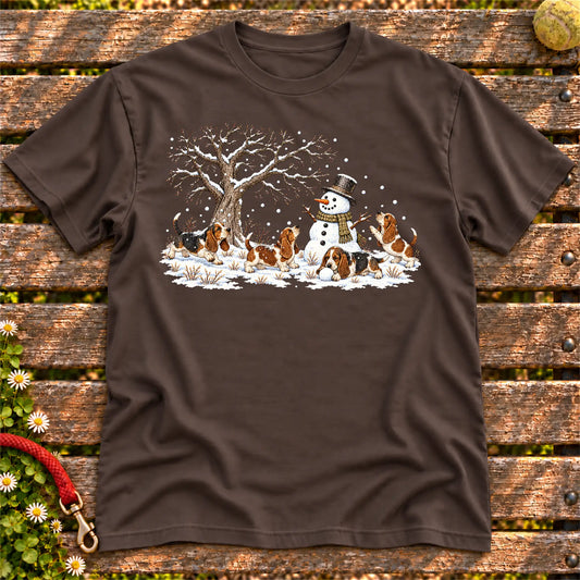 Basset Hound puppies playing in snow with a snowman on a Dark Chocolate T-shirt