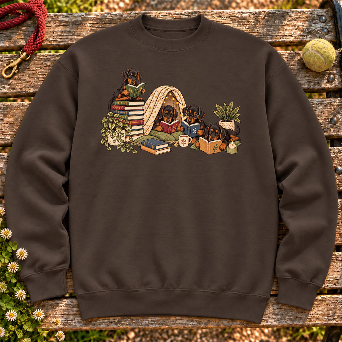 Doberman puppies reading books in a cozy blanket fort on a Dark Chocolate sweatshirt