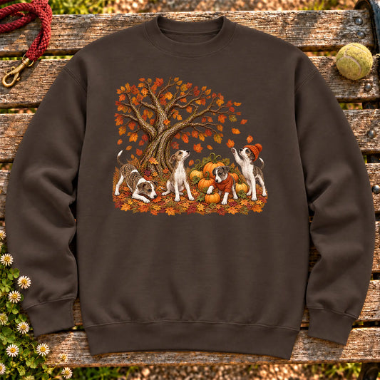 Four Greyhound puppies with pumpkins beneath an autumn tree on a Dark Chocolate crewneck sweatshirt