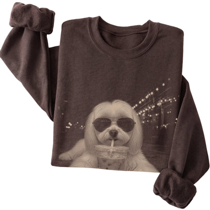 Maltese wearing aviator sunglasses and drinking iced coffee on a Dark Chocolate Gildan Heavy Blend Crewneck Sweatshirt, folded view