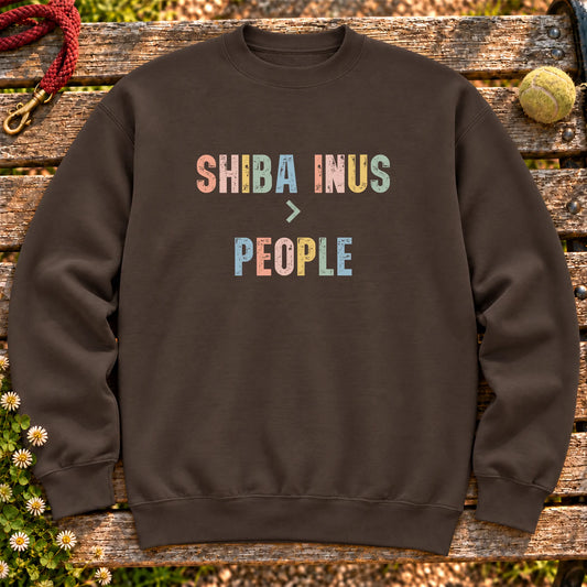 Shiba Inus greater than people text design on a Dark Chocolate crewneck sweatshirt