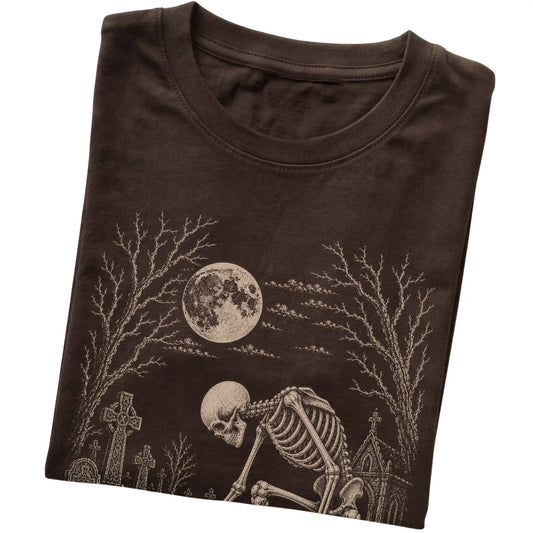Folded Dark Chocolate T-shirt with a skeleton petting a Dachshund in a graveyard