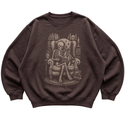 Skeleton reading Tales Beyond to a Boston Terrier on a Dark Chocolate sweatshirt