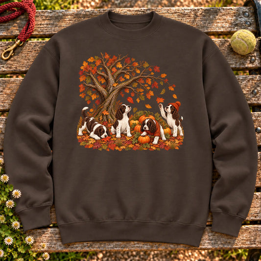 Four Springer Spaniel puppies with pumpkins beneath an autumn tree on a Dark Chocolate crewneck sweatshirt