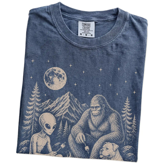 Folded Denim Comfort Colors® T-shirt showing American Bulldog camping with Bigfoot and an alien