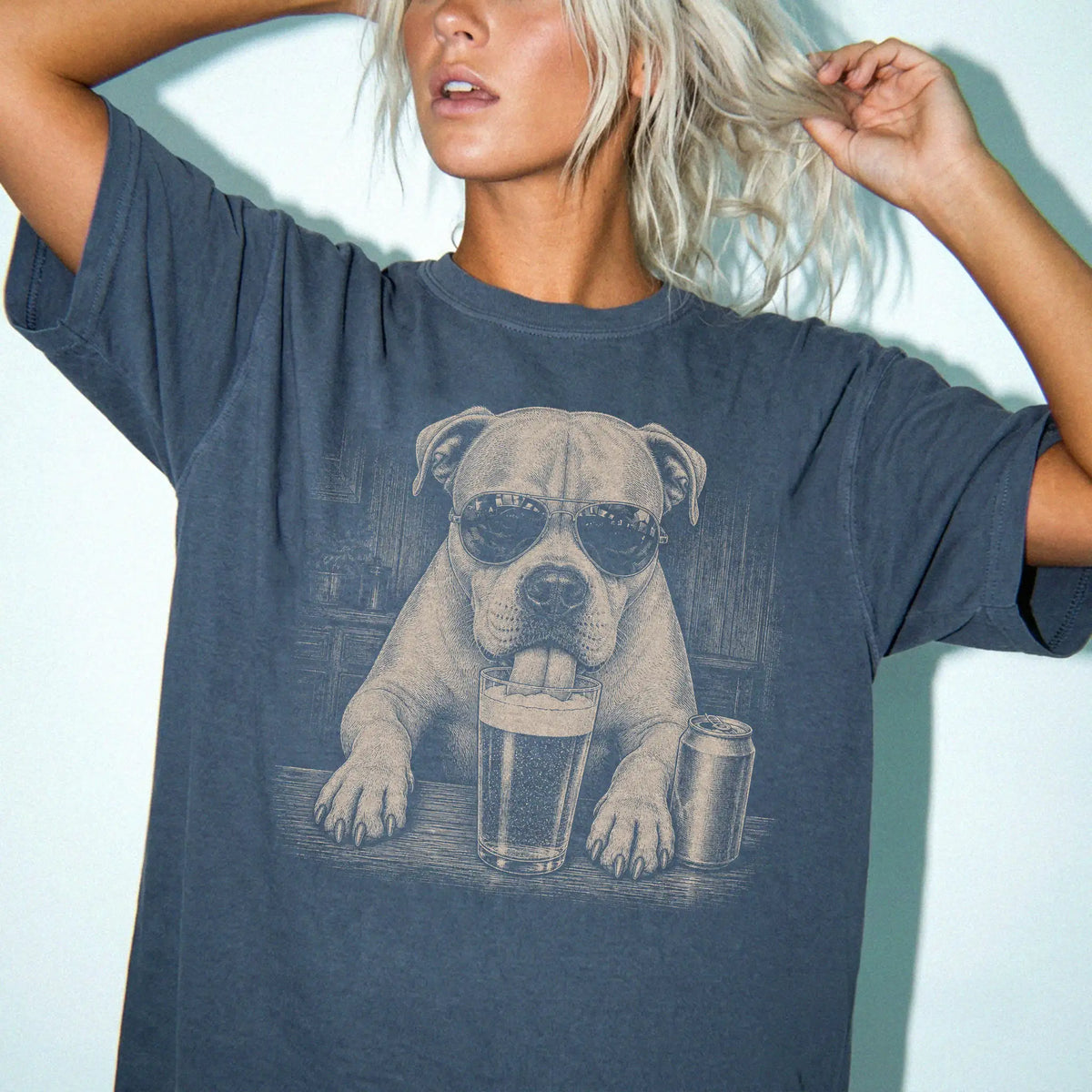 Model wearing a Denim Comfort Colors® t-shirt with American Bulldog sneaking a drink from a pint